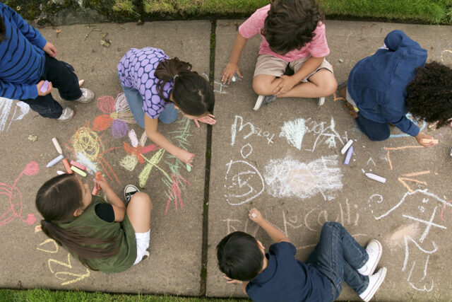 Kids play together on neighborhood sidewalk afterschool
