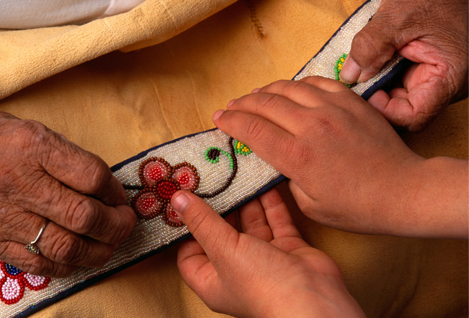 Native American grandmother and child doing bead work