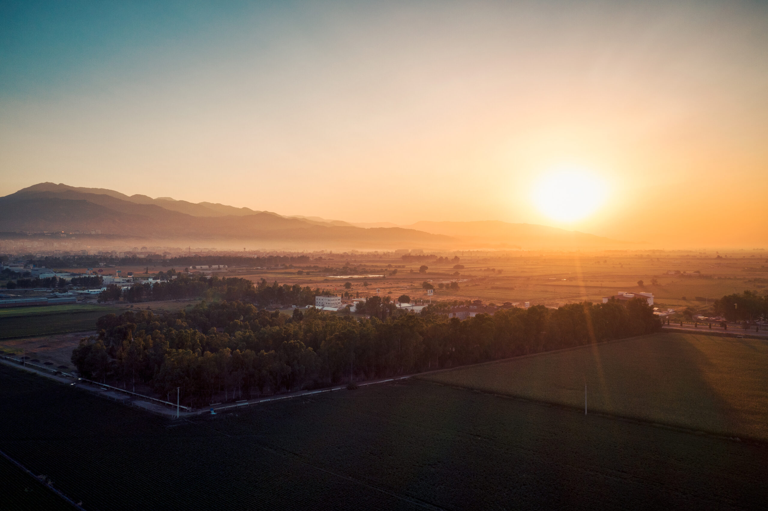 Sun rises over the hills and on a small town.